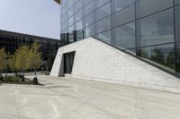 a person riding a skateboard on a cement patio near a building, near a park