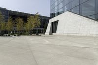 a person riding a skateboard on a cement patio near a building, near a park