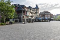 the large stone pavement in front of a city square with people walking and sitting on benches