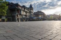 the large stone pavement in front of a city square with people walking and sitting on benches