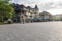 the large stone pavement in front of a city square with people walking and sitting on benches