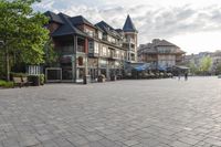 the large stone pavement in front of a city square with people walking and sitting on benches