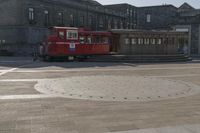 a trolley is sitting alone on the ground in the city square near many large buildings