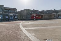 a trolley is sitting alone on the ground in the city square near many large buildings