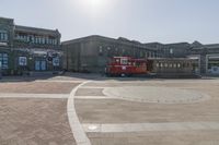 a trolley is sitting alone on the ground in the city square near many large buildings