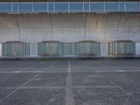 two empty parking spaces with two empty doors and a large window on the wall between two buildings