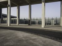 empty parking lot with metal partitions on both sides, outside an airport terminal building