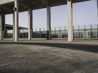 empty parking lot with metal partitions on both sides, outside an airport terminal building