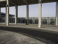 empty parking lot with metal partitions on both sides, outside an airport terminal building