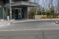 a building has a glass front door, and a small fire hydrant on the curb