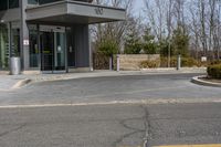 a building has a glass front door, and a small fire hydrant on the curb