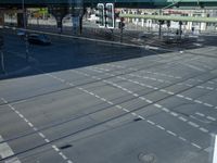 cars and buses on the street and in front of a pedestrian walkway near a green pedestrian bridge