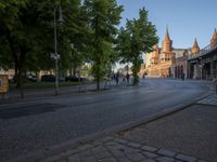a city street is lined with a bridge and old buildings and tall steeps with spires