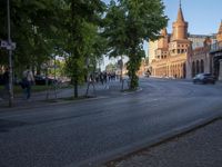 a city street is lined with a bridge and old buildings and tall steeps with spires