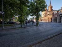 a city street is lined with a bridge and old buildings and tall steeps with spires