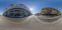 a fish eye lens image of cars on the street near a building with several arches