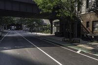 a bus drives down the street under an overpass in this city alley and sidewalk