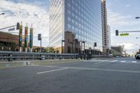 a city street has multiple lines and empty traffic lanes in the middle of it with buildings along side and street signs