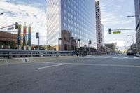 a city street has multiple lines and empty traffic lanes in the middle of it with buildings along side and street signs