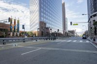 a city street has multiple lines and empty traffic lanes in the middle of it with buildings along side and street signs