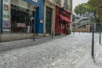 a street with some buildings next to a sidewalk with bars that line the side of it