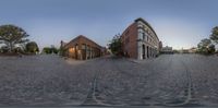 a 3d photo of a city street with cobblestone floors and buildings and a red brick building