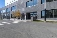 a street corner with a brick building and parking lot at the edge of the road