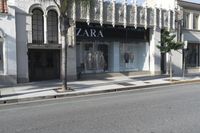 a street corner with an advertisement for the zara outlet on the wall and trees