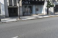 a street corner with an advertisement for the zara outlet on the wall and trees