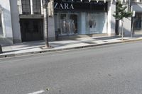 a street corner with an advertisement for the zara outlet on the wall and trees