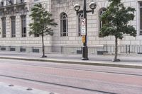 this is some street lights and a sidewalk in front of a building with windows on the side