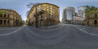 a 360 camera view of a city street in the daytime with cars passing by on it