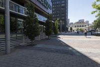 this is a city street with people walking around it on a sunny day outside of the building