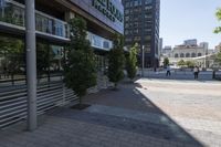 this is a city street with people walking around it on a sunny day outside of the building