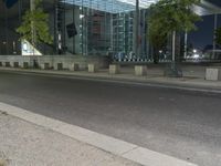 a city street in the evening with a traffic light on it's side and an empty road to the right of the building