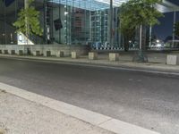 a city street in the evening with a traffic light on it's side and an empty road to the right of the building