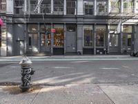 a city street with a fire hydrant on a sidewalk in front of a building