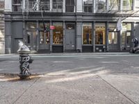 a city street with a fire hydrant on a sidewalk in front of a building