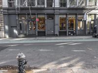 a city street with a fire hydrant on a sidewalk in front of a building