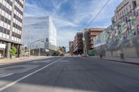 a city street with several tall buildings in the background, a man is driving on his motorcycle