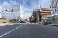 a city street with several tall buildings in the background, a man is driving on his motorcycle