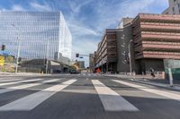 a city street with several tall buildings in the background, a man is driving on his motorcycle