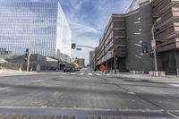 a city street with several tall buildings in the background, a man is driving on his motorcycle