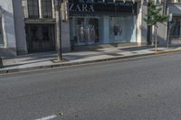 the store front of zara by a street with palm trees and building in the background