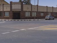 a building with the sign that reads to the right of the road is a closed street, with a yellow line on the road in front of it, and some buildings