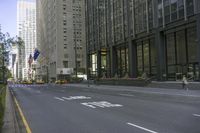 city street and busses near tall building with sky blue sky background, with a traffic cone on side