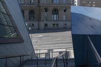 an angled view down from some stairs in the city of a city street with buildings in the background