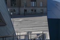 an angled view down from some stairs in the city of a city street with buildings in the background