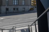 an angled view down from some stairs in the city of a city street with buildings in the background