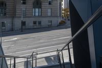 an angled view down from some stairs in the city of a city street with buildings in the background